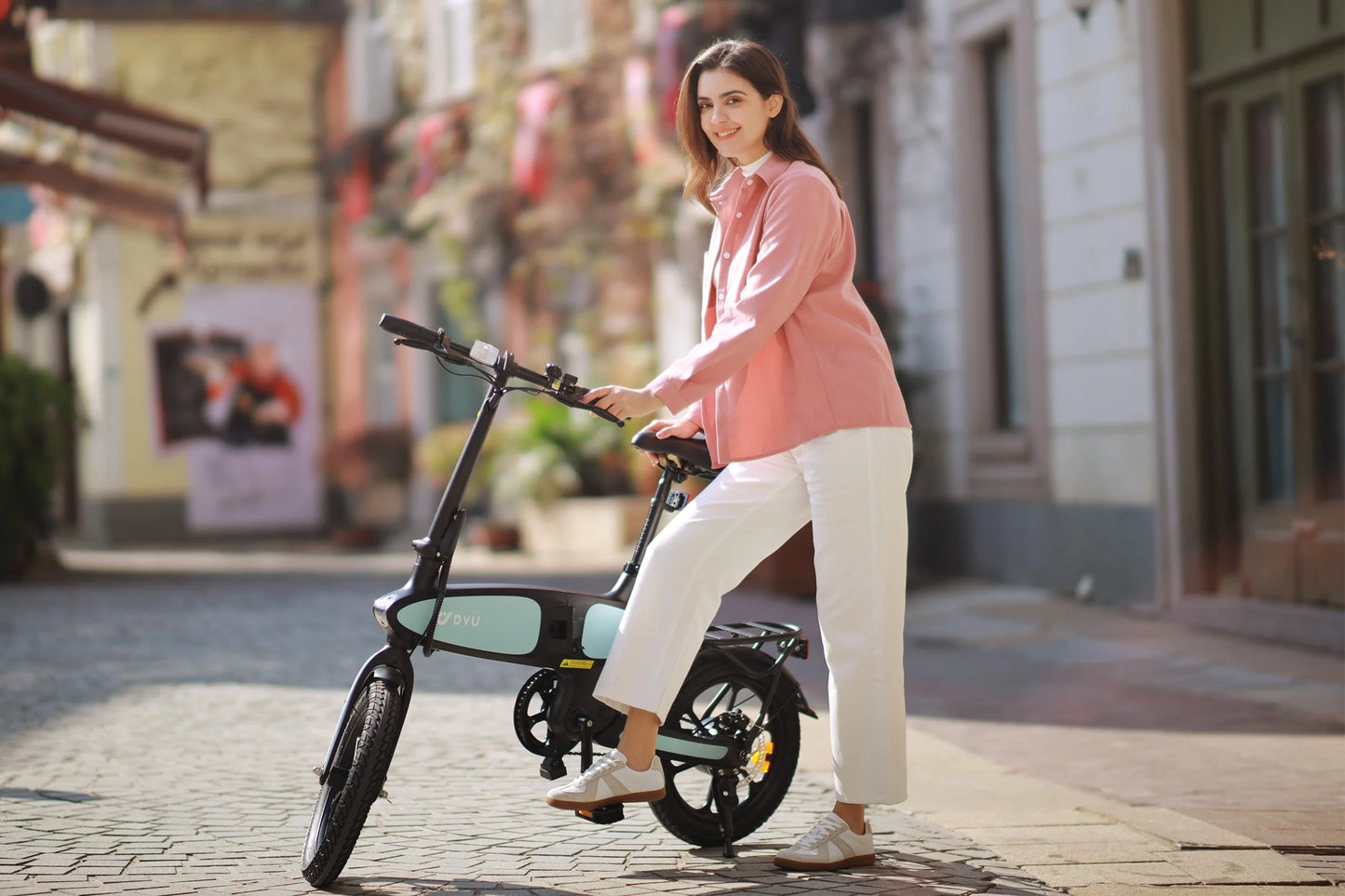 Woman standing with DYU C2 16 Inch Full Folding Electric Bike with 250W Mottor and 48V7.5AH Battery on cobblestone street