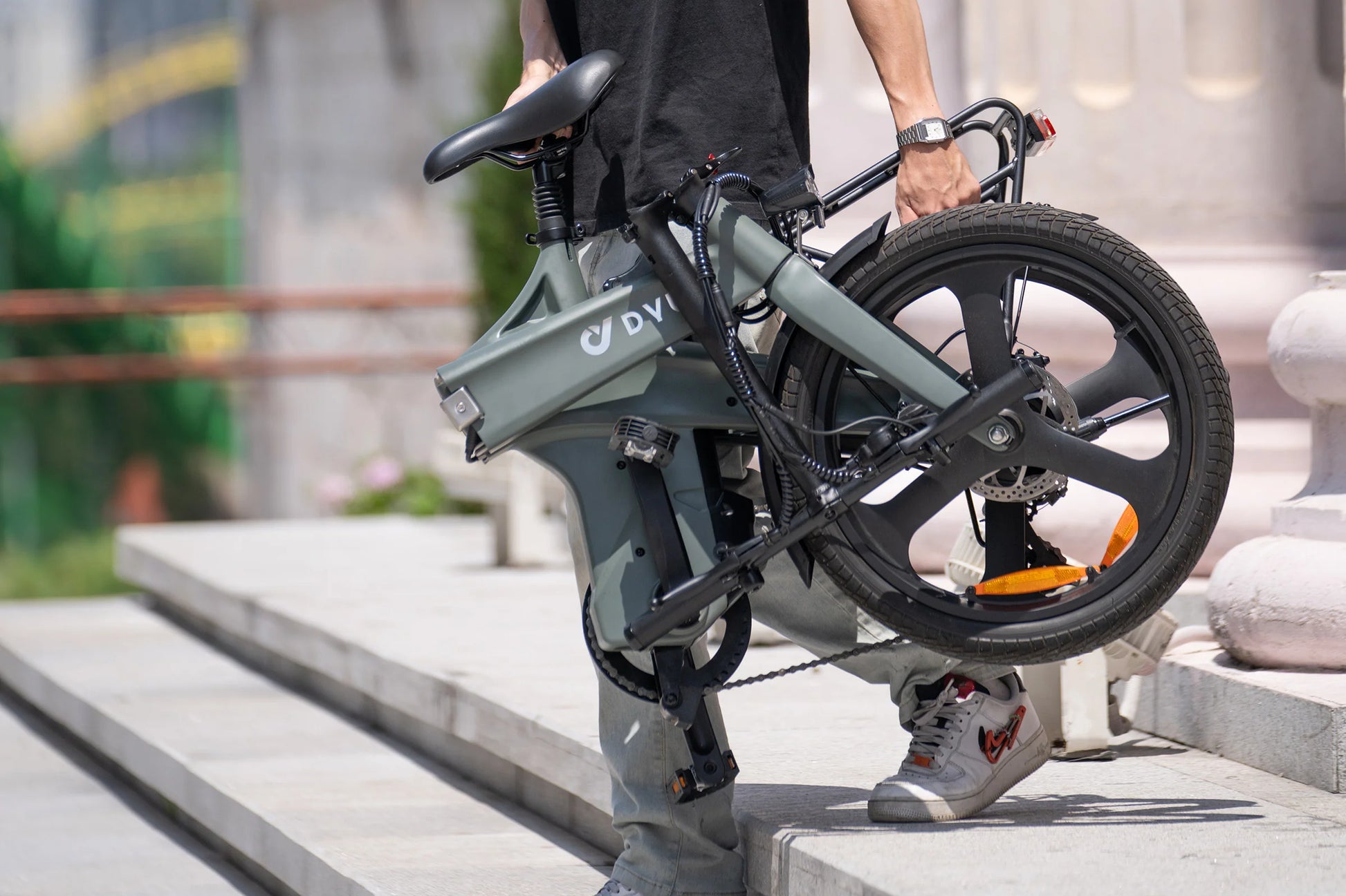 DYU T1 20 Inch Foldable Electric Bike with magnesium alloy frame and dual disc brakes carried by person